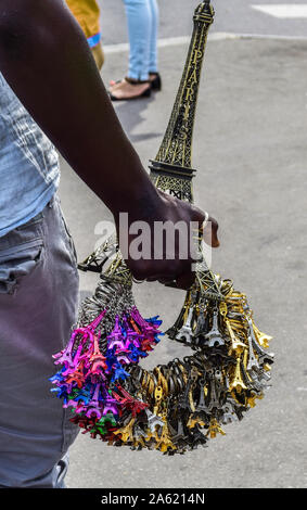 Eine schwarze Hand ein Bündel von verschiedenen farbigen Eiffelturm Schlüsselanhänger in Paris, Frankreich Stockfoto