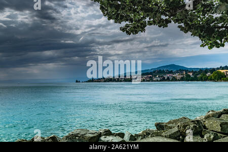 Ansicht der Stadt von Clarens am Ufer des Genfer Sees und dunklen regnerischen Wolken. Montreux, Schweiz. Stockfoto