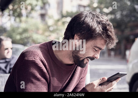 Attraktiven jungen bärtigen Mann mit seinem Smartphone im Cafe Stockfoto