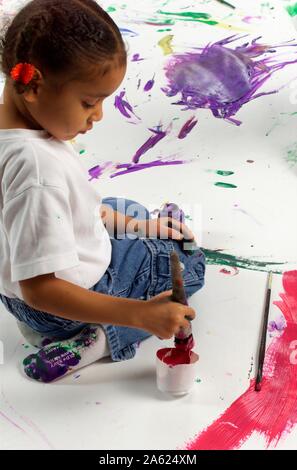 Ansicht von oben der afroamerikanischen Kinder malen auf eine große weiße Oberfläche mit Aquarellfarben Stockfoto