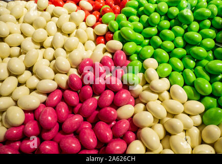 Nahaufnahme von Schalen mit einer großen Auswahl an verschiedenen Farben Bonbons gefüllt. Grün, Weiß, Rot und Rosa Bonbons Stockfoto