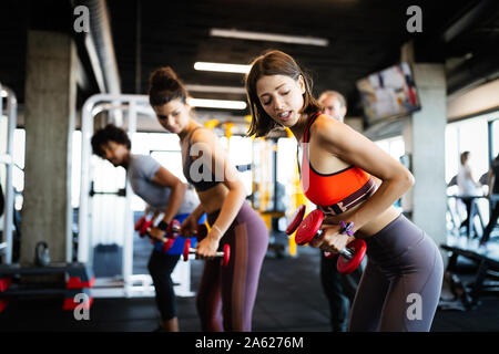 Fitness, Sport, Training und Lifestyle Konzept. Gruppe von Menschen, die das Trainieren im Fitnessstudio Stockfoto