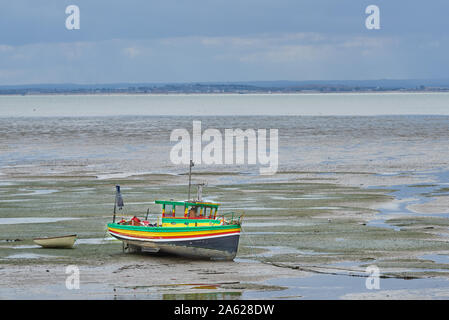 Bunte Boot auf dem Wattenmeer des Flusses vertäut Thames Estuary im Thorpe Bay, Southend-on-Sea, Essex, England. Stockfoto