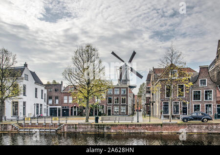 Schiedam, Niederlande, 23. Oktober 2019: Blick über den Hafen in Richtung Fischmarkt Platz, mit einer Windmühle, alte Laternen und Häuser und ein Stockfoto