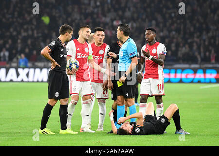 Amsterdam, Niederlande. 23 Okt, 2019. AMSTERDAM, 23-10-2019 JohanCruyff Arena, Champions League Fußball Saison 2019/2020 Ajax-player Dusan Tadic Ajax-player Lisandro Martinez Schiedsrichter Ovidiu Hategan und Ajax-player Quincy Promes während des Spiels Ajax-FC Chelsea. Credit: Pro Schüsse/Alamy leben Nachrichten Stockfoto
