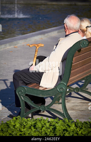 Charkow, Ukraine - Oktober 14, 2019: Elegante ältere Paare sitzen auf einer Bank im Herbst Park Stockfoto