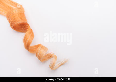 Menschliche, natürliche Honigfarbe blonde Haare auf weißem Hintergrund isoliert. Elegante, modische Farben in diesem Jahr. Honig blonde Locken oder sperren. Stockfoto