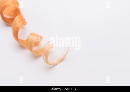 Menschliche, natürliche Honigfarbe blonde Haare auf weißem Hintergrund isoliert. Elegante, modische Farben in diesem Jahr. Honig blonde Locken oder sperren. Stockfoto