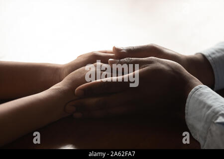 Nahaufnahme der tausendjährigen afrikanischen amerikanische liebevoller Mann Holding wifes Hände. Stockfoto