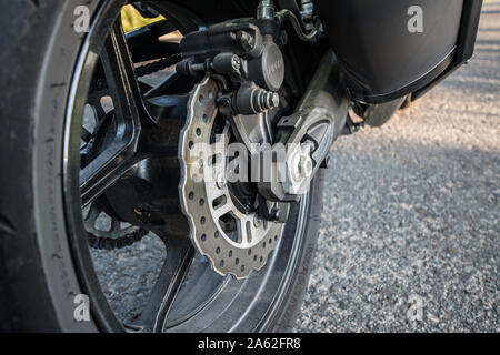Polen, Sommer: Motorrad auf der rechten Seite. Nahaufnahme der Bremsscheibe hinten, Rad und Kette. Stockfoto