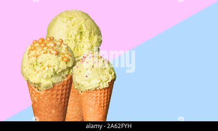 Eine Reihe von Pistazien oder mint Eis in der Waffel auf einem Pastell 2-farbigen Hintergrund. Knöpfe, Kugeln Eis verziert mit goldenen und bunten sprinkl Stockfoto