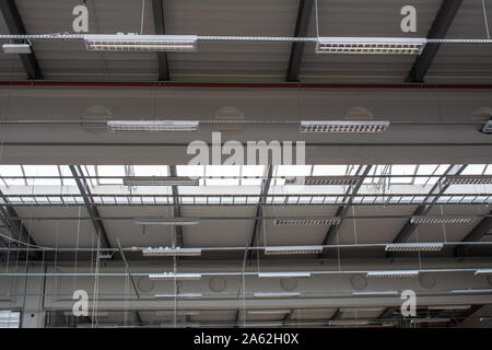 Lager- oder Produktionshalle Decke Licht Industrie Leuchtstoffröhren. Oberlichter. Balken auf dem Dach. Stockfoto