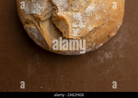 Ansicht von oben für eine knusprige, goldene, mit Mehl Brot, gebacken auf sauerteig. Isolierten Ort für Text oder Untertitel. Runde Laib frisch gebackene Brot, Kopie Raum Stockfoto