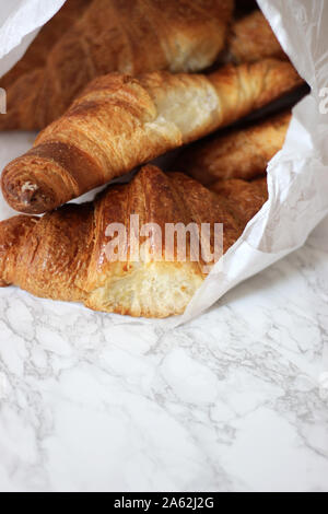 Frisch gebackene Croissants in Papiertüte. Klassische französische Croissants von Bäckerei in Paris. Stockfoto