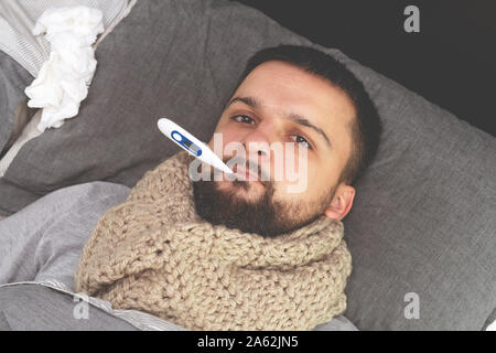 Krankheit. Zu Hause erfreuen. Ein junger Mann ist krank, ist zu Hause behandelt. Infektion, Epidemie, Bacillus Träger. Stockfoto