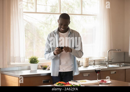 Happy african american man Vorbereitung romantisches Abendessen für geliebte Frau. Stockfoto