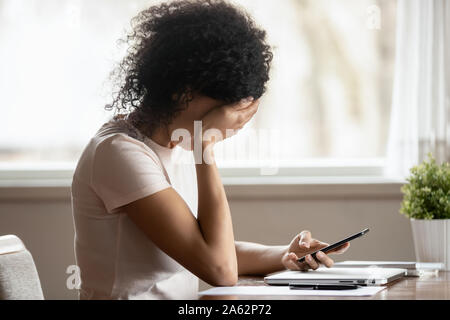 Gedrückt traurige tausendjährigen afrikanischen ethnische Frau empfing schlechte Nachrichten. Stockfoto