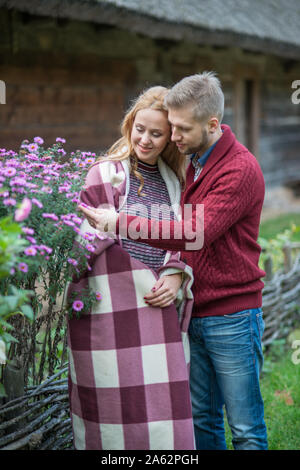 Schöne schwangere Frau mit ihrem Mann zu Fuß im Herbst Park Stockfoto