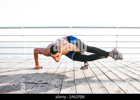 Junger Mann eine bakasana, Kran Pose während eines intensiven Yoga Praxis Stockfoto