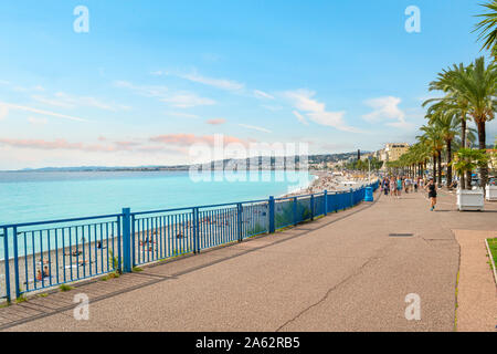 Jogger und Walker Pass das Mittelmeer und den Strand entlang der Promenade des Anglais an der französischen Riviera in Nizza Frankreich Stockfoto