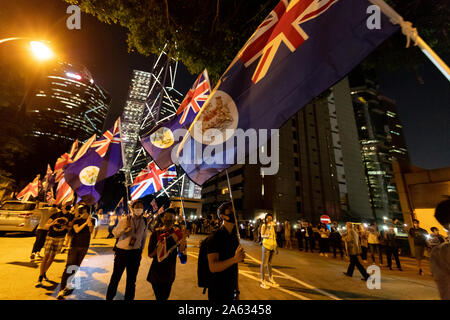 Maskierte Demonstranten halten britischen Flaggen und bilden eine Menschenkette vor dem britischen Konsulat, fordert die britische Regierung die Motion Debatte im House of Lords der zweiten Staatsbürgerschaft für Menschen in Hongkong zu unterstützen. Stockfoto