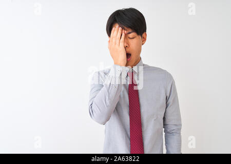 Chinesischen Geschäftsmann tragen elegante Krawatte stehend über isoliert weißer Hintergrund Gähnen müde die halbe Gesicht, Augen und Mund mit der Hand. Gesicht weh tut Stockfoto