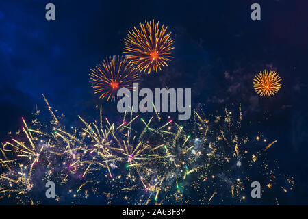 Preiswertes Feuerwerk über dem blauen Himmel, Rot, Gelb, Grün, Blau und Weiß mit Farbe Funken. Hell und glänzend. Feier Konzept. Stockfoto