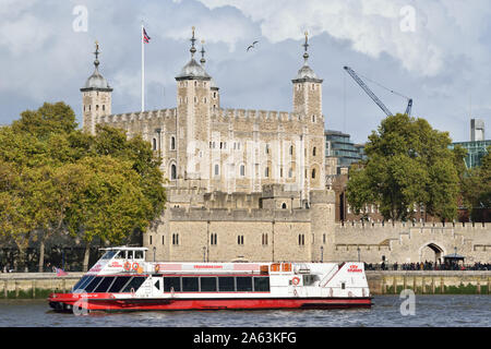 Eines der City Cruises London Sightseeing-Boote auf der Themse vorbei an den Tower of London Stockfoto