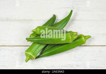 Grüne Okra / Frische Frische junge Okra für Lebensmittel auf weißem Holz-, Ochro Gumbo Stockfoto