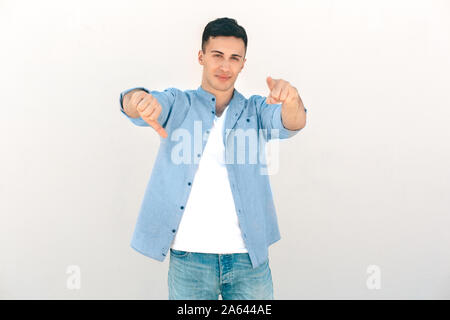 Freizeitaktivitäten im Freien. Stilvolle Kerl stehen auf weißen zeigen auf Kamera Daumen isoliert sie lächelnd cool Stockfoto