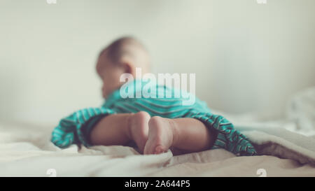 Cute Baby Boy Rolling auf dem Bett und Spielen zu Hause Stockfoto