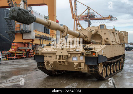 Ein Soldat, die ein M109A6 'Paladin' vom 1.BATAILLON, 5 Field Artillery, 1st Armored Brigade Combat Team, 1.Infanterie Division erwartet Hochladen auf den Green Ridge Schiff im Hafen am Hafen von Gdynia, Polen, 18.Oktober 2019. Der Teufel Brigade Soldaten sollen sich zurück zu Home Station zu Kopf, nachdem sie in ganz Osteuropa für die letzten neun Monate lang bereitgestellt als die Drehkraft zur Unterstützung der US-Armee in Europa und Atlantik lösen. (U.S. Armee Foto: Staff Sgt. Wahre Thao) Stockfoto