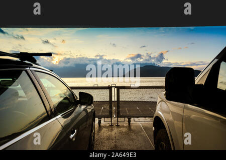 Sonnenaufgang über Meer und Berge von der Vorderseite der Fähre mit dem Auto Deck, in Richtung Osten aus Gibsons in Richtung Vancouver, Kanada. Stockfoto