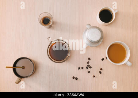 Tassen Kaffee mit Kaffeebohnen und vietnamesische Phin Filter auf Holz- Hintergrund Stockfoto