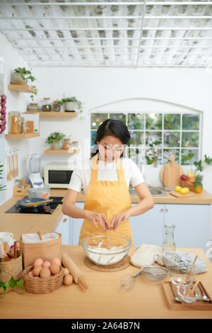 Frau Risse Eier in Glasschale Stockfoto