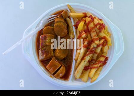 Currywurst mit Pommes Frites mit Kunststoff Gabel auf eine Kunststoffplatte, Fast Food, Deutschland Stockfoto