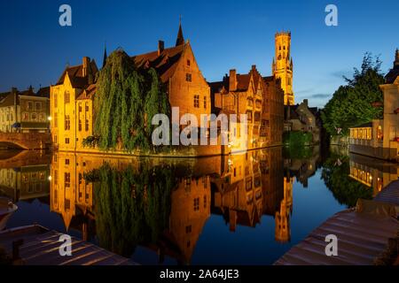Beleuchtete historische Häuser mit Wasser Reflexion während der Dämmerung, Rozenkaai, Brügge, Belgien Stockfoto