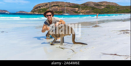 Kaukasische Mann mit einer schönen Kangaroo bei Lucky Bay Beach im Cape Le Grand National Park in der Nähe von Esperance, Australien Stockfoto