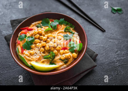 Vegetarische Laksa Suppe. Gemüse Nudel laksa Suppe auf schwarzem Hintergrund, Ansicht von oben, kopieren. Asiatische Malaysischen vegan vegetarisch essen. Stockfoto
