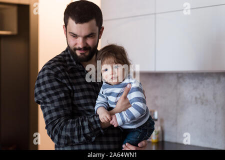 Vater Holding 8-Monate alten Sohn, ihm saures Aufstoßen nach dem Füttern. Stockfoto