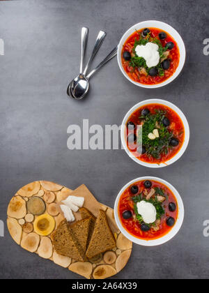 Traditionelle ukrainische Russischen Borschtsch mit Oliven, Dill, Knoblauch, Schmalz zu den Schalen. Rote-bete-Suppe Ansicht von Oben. Traditionelle ukrainische Essen Küche. Kopieren spa Stockfoto