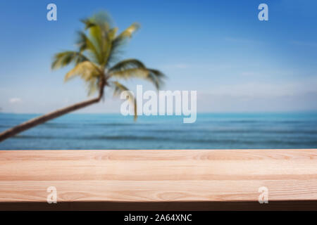 Leere Holztisch auf dem Hintergrund der tropischen Strand mit Palmen. Stockfoto