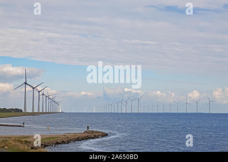 Zeilen von Windmühlen im Meer stehen. Stockfoto