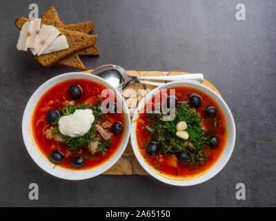 Traditionelle ukrainische Russischen Borschtsch mit Oliven, Dill, Knoblauch, Schmalz zu den Schalen. Rote-bete-Suppe Ansicht von Oben. Traditionelle ukrainische Essen Küche. Kopieren spa Stockfoto