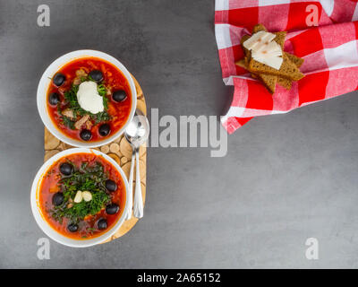 Traditionelle ukrainische Russischen Borschtsch mit Oliven, Dill, Knoblauch, Schmalz zu den Schalen. Rote-bete-Suppe Ansicht von Oben. Traditionelle ukrainische Essen Küche. Kopieren spa Stockfoto