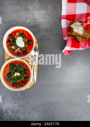 Traditionelle ukrainische Russischen Borschtsch mit Oliven, Dill, Knoblauch, Schmalz zu den Schalen. Rote-bete-Suppe Ansicht von Oben. Traditionelle ukrainische Essen Küche. Kopieren spa Stockfoto