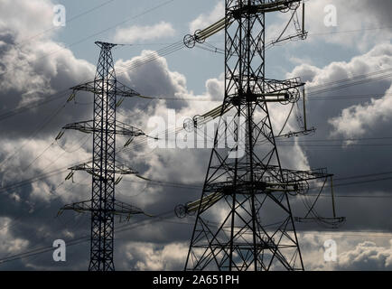 Ansicht der Hochspannungsleitungen auf gegen Grau stürmischen Wolken. Stockfoto