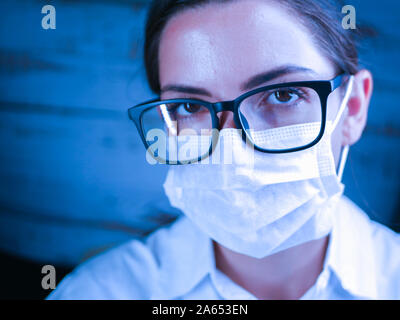Nahaufnahme von einer Krankenschwester. Arzt, Krankenschwester, hinter der Maske eines Chirurgen. Closeup Portrait einer jungen kaukasischen Frau Modell mit schwarzen Gläsern Stockfoto