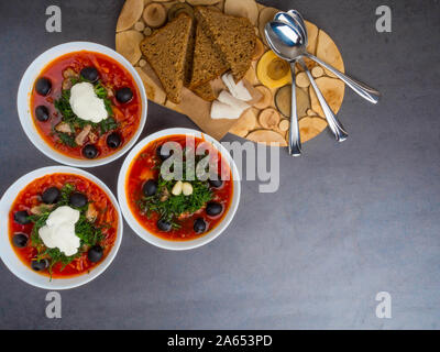 Traditionelle ukrainische Russischen Borschtsch mit Oliven, Dill, Knoblauch, Schmalz zu den Schalen. Rote-bete-Suppe Ansicht von Oben. Traditionelle ukrainische Essen Küche. Kopieren spa Stockfoto