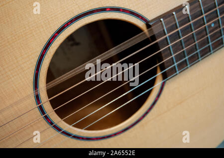 Aus einer Reihe von Nahaufnahmen von akustischen Gitarren Sound Loch und Stahlsaiten, mit wechselnden Saiten vibrieren nach ausgewählt werden. Stockfoto